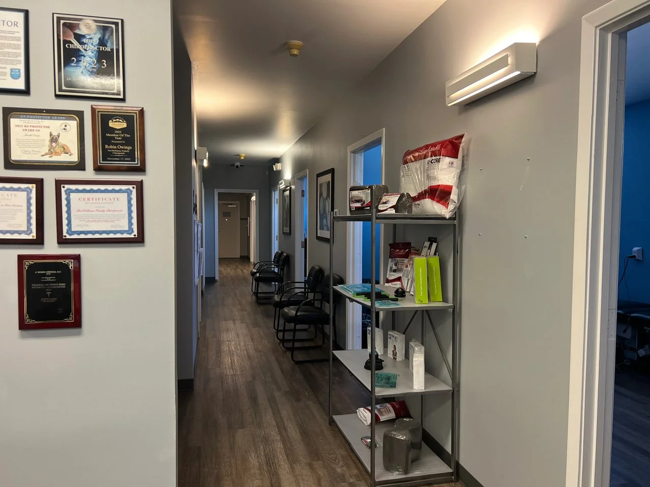 The main hallway inside the ProWellness Family Chiropractic clinic in Lincolnton, lined with awards and patient-care products