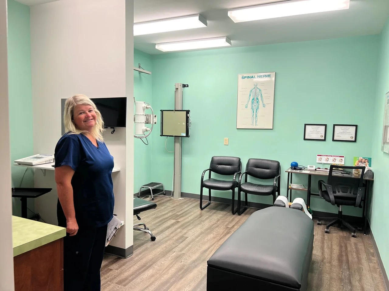 A friendly staff member inside a clean and modern patient examination room at the clinic