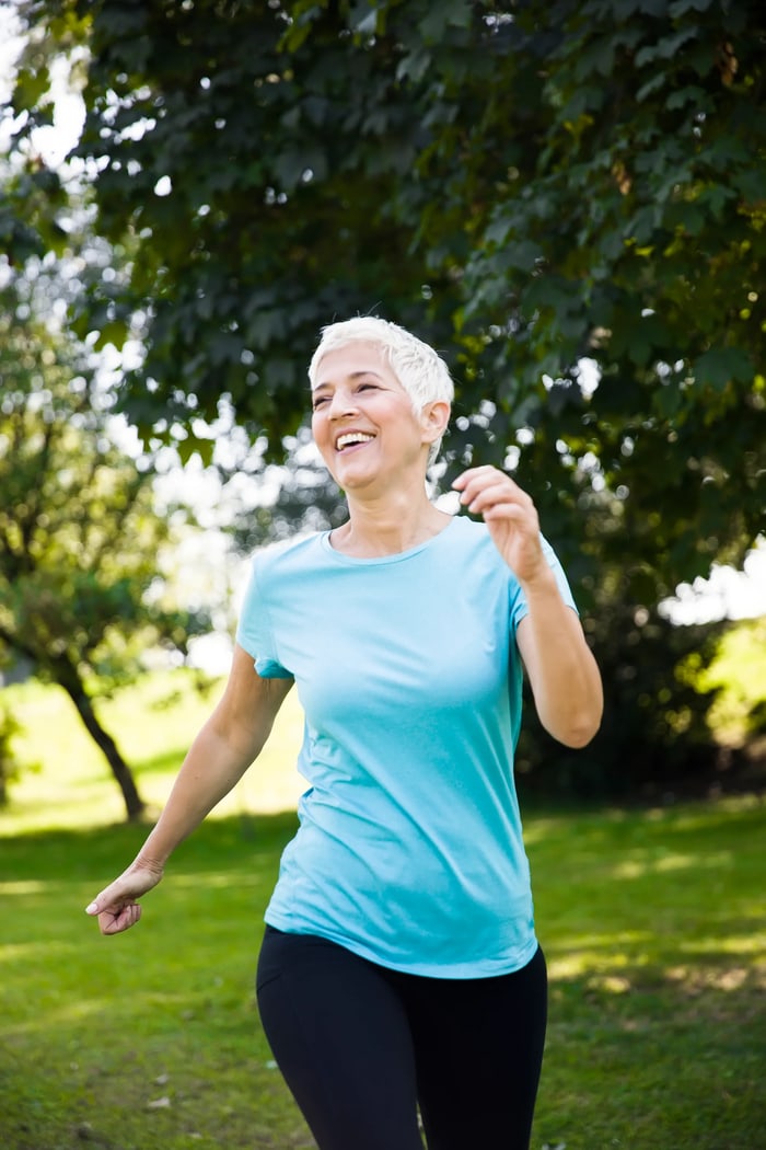 Smiling senior woman walking outdoors in activewear