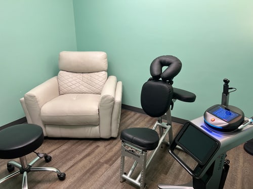 ProWellness laser therapy room with a comfortable recliner beside the Class IV laser unit