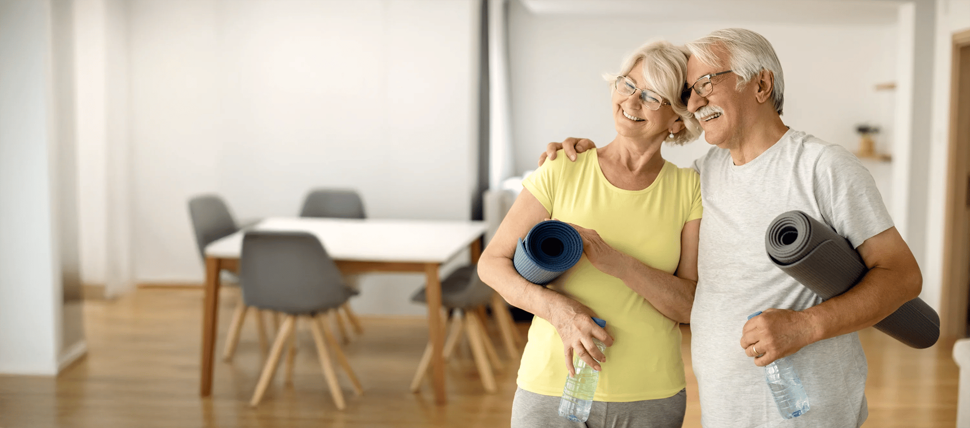 Senior couple practicing gentle yoga stretches together