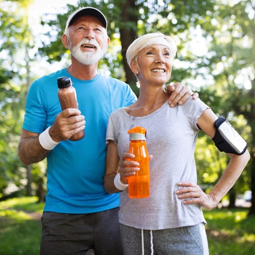 Active senior couple smiling outdoors after exercise