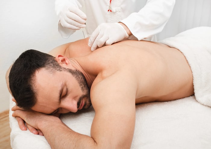 Relaxed patient lying face down during a gloved dry needling session