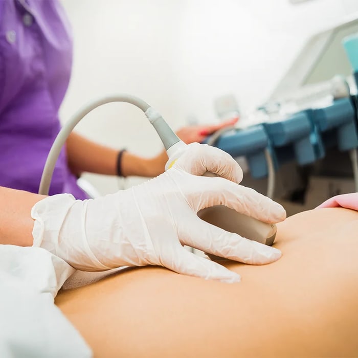 Provider gliding a therapeutic ultrasound wand over a patient’s skin